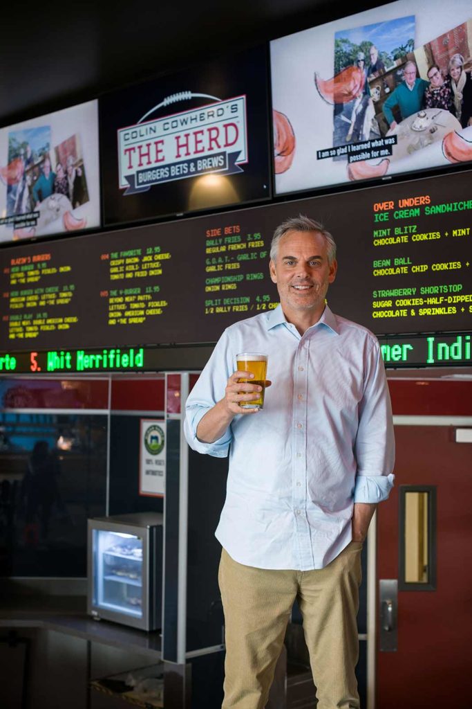 Colin Cowherd holding a glass of beer