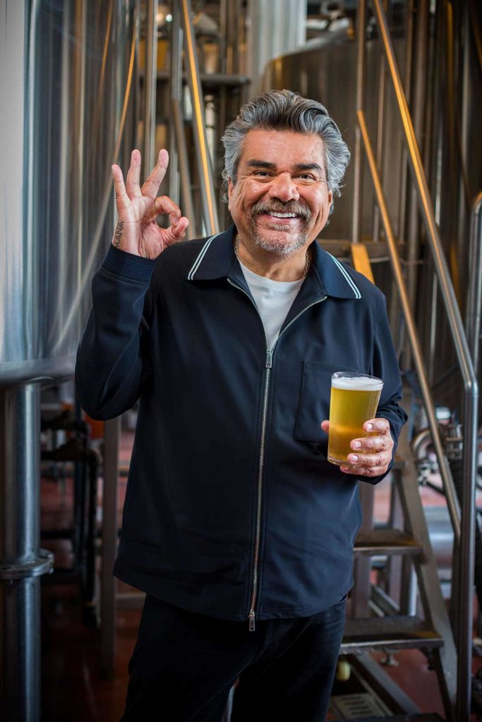George Lopez holding a glass of beer